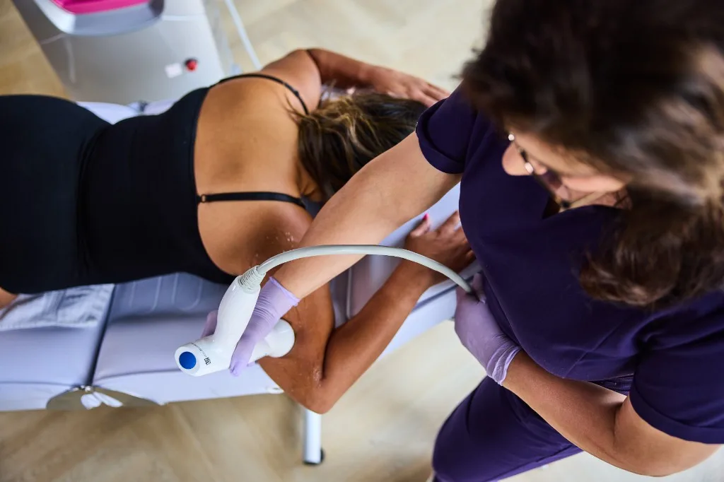 Overhead view of upper-arm body contouring treatment with handheld RF device