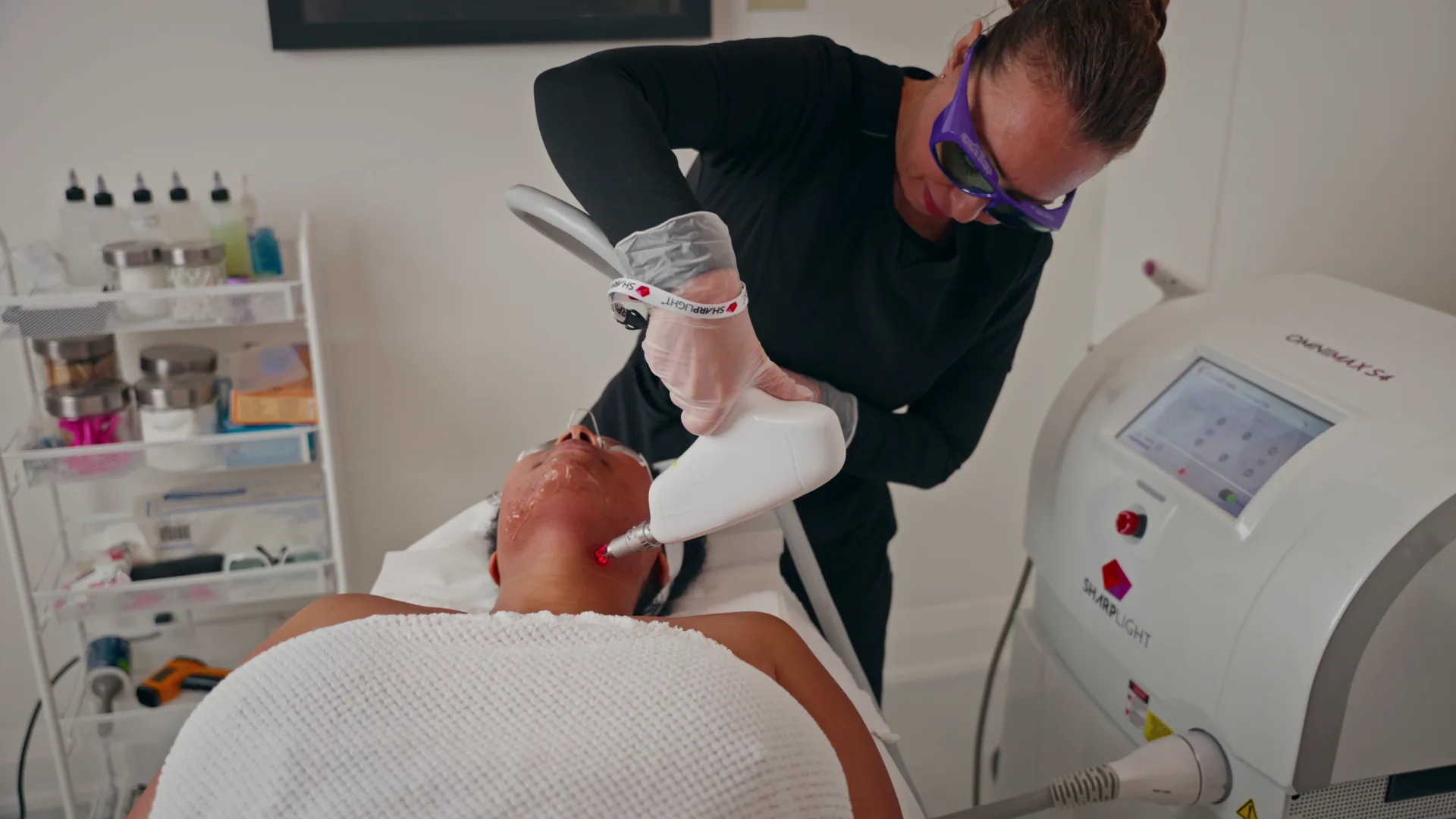 Practitioner performing a facial laser treatment with the OmniMax S4 workstation